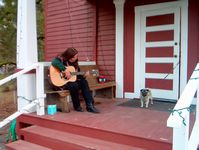 A patron gets musical on the Schoolhouse porch